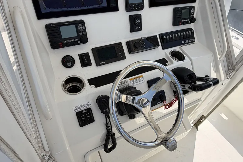 Slide: The Image of 2015 Regulator 34 Center Console boat dashboard with steering wheel and navigation controls. - 4
