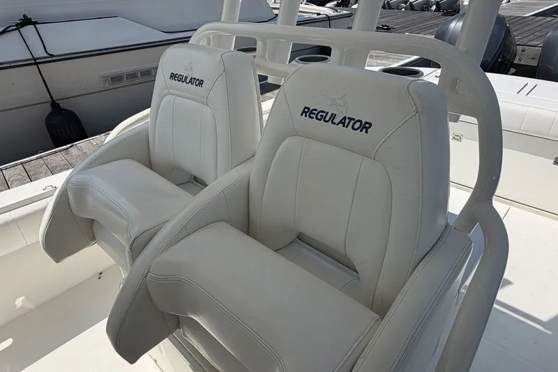 Slide: The Image of 2015 Regulator 34 Center Console boat seats, white leather, docked at marina. - 5