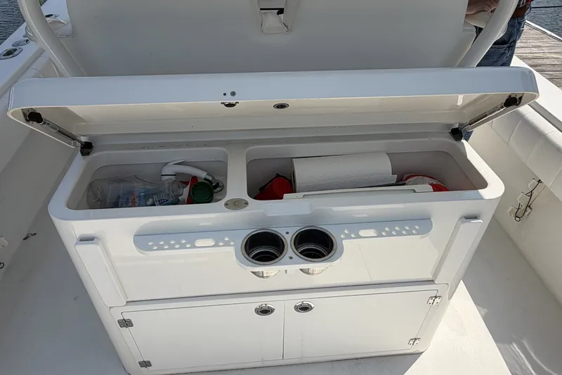 Slide: The Image of Open storage compartment on 2015 Regulator 34 Center Console boat, containing various items. - 7
