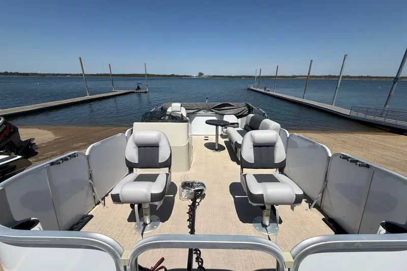 Slide: The Image of 2020 SunCatcher V18 Fish pontoon boat docked by a serene lake under clear skies. - 21