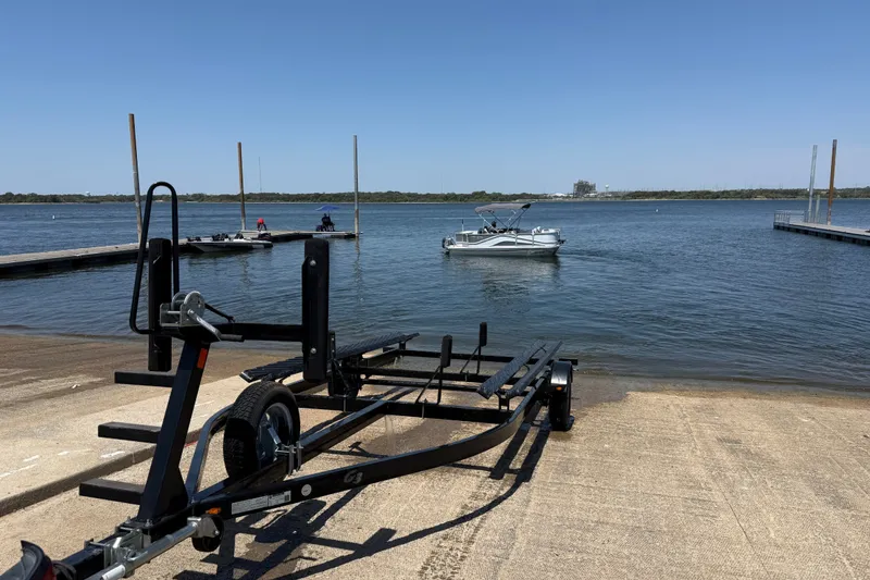 Slide: The Image of Boat trailer near water with 2020 SunCatcher V18 Fish pontoon boat in the background. - 34