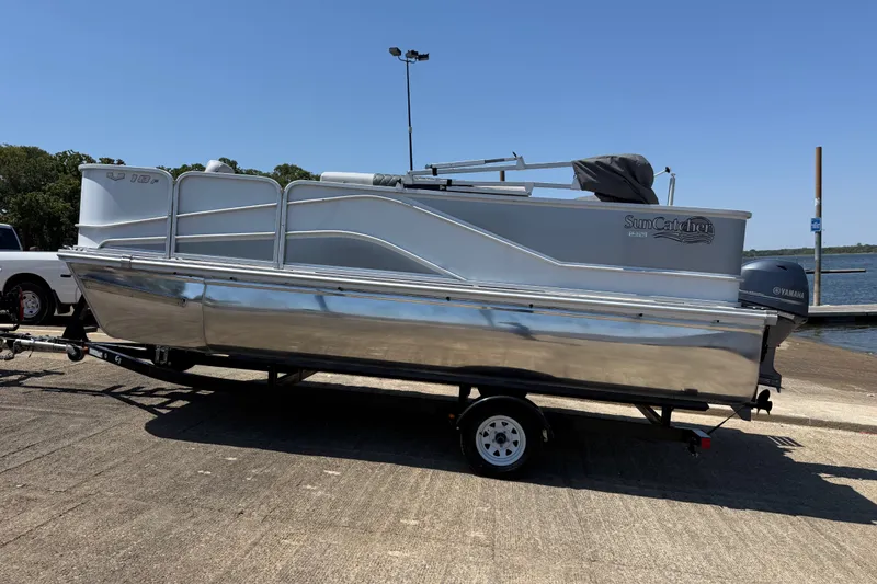 Slide: The Image of 2020 SunCatcher V18 Fish pontoon boat on trailer by the water. - 13