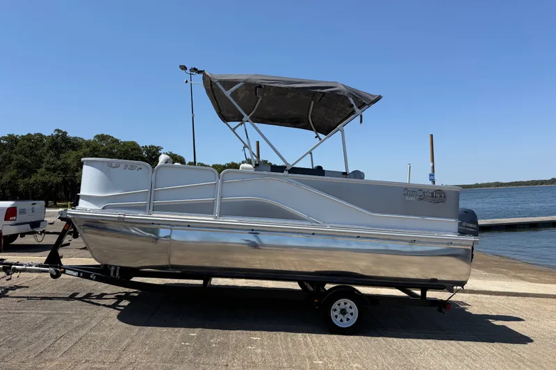 Slide: The Image of 2020 SunCatcher V18 Fish pontoon boat on trailer by a lake under clear sky. - 32
