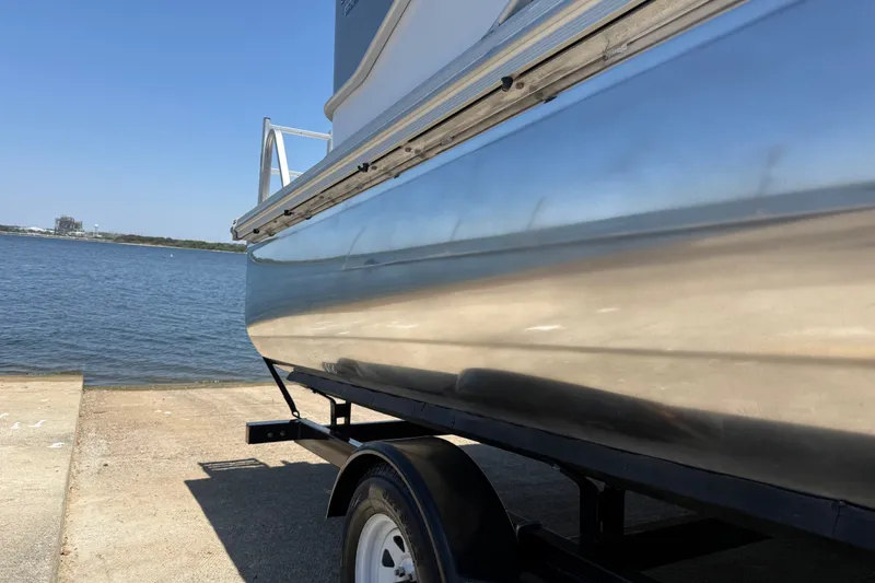 Slide: The Image of 2020 SunCatcher V18 Fish boat on trailer by the water. - 20