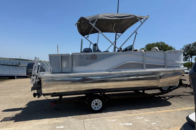 Slide: The Image of 2020 SunCatcher V18 Fish pontoon boat on trailer, featuring a canopy and Yamaha motor. - 28