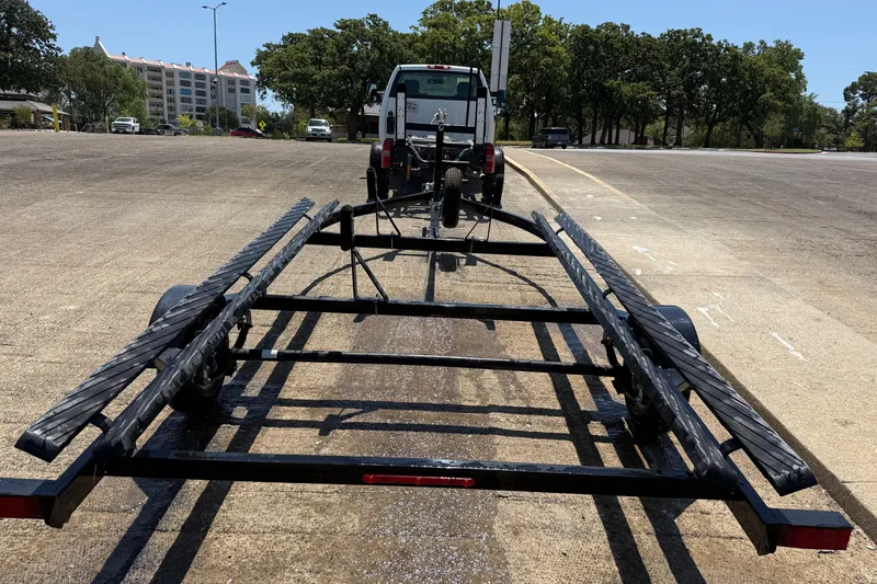 Slide: The Image of Empty boat trailer hitched to a truck, SunCatcher V18 Fish, 2020 model, in a parking lot. - 36