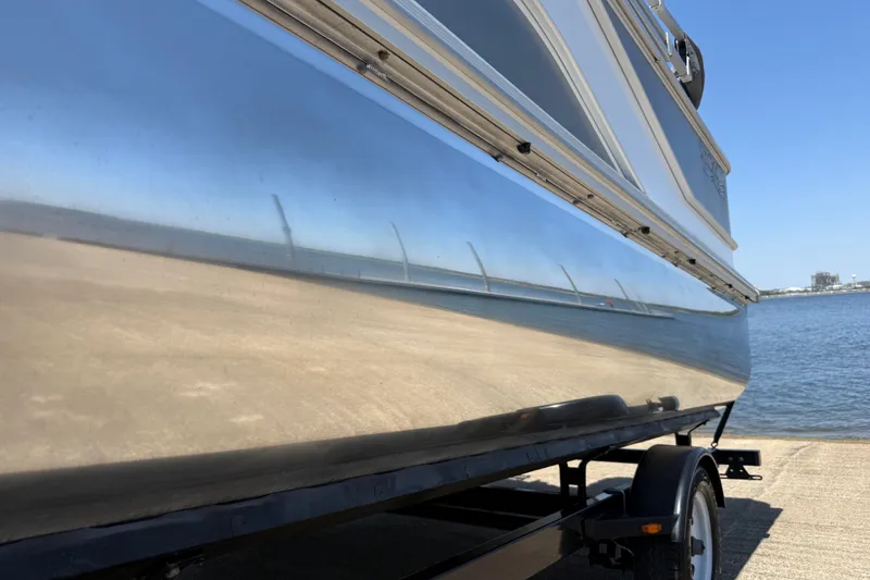 Slide: The Image of 2020 SunCatcher V18 Fish boat on trailer by the water. - 19