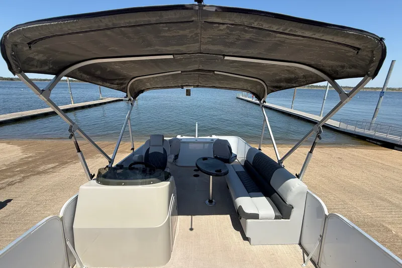 Slide: The Image of 2020 SunCatcher V18 Fish pontoon boat with canopy, docked by a serene lake. - 26
