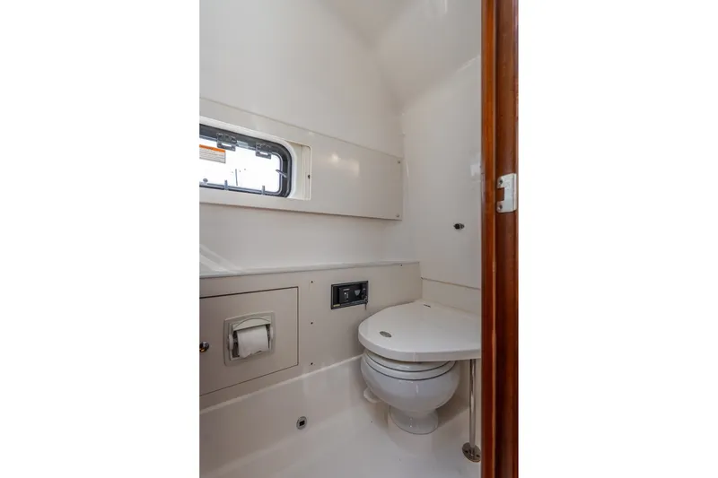 Slide: The Image of 2022 Pursuit S 428 Sport boat bathroom interior with toilet and window. - 52