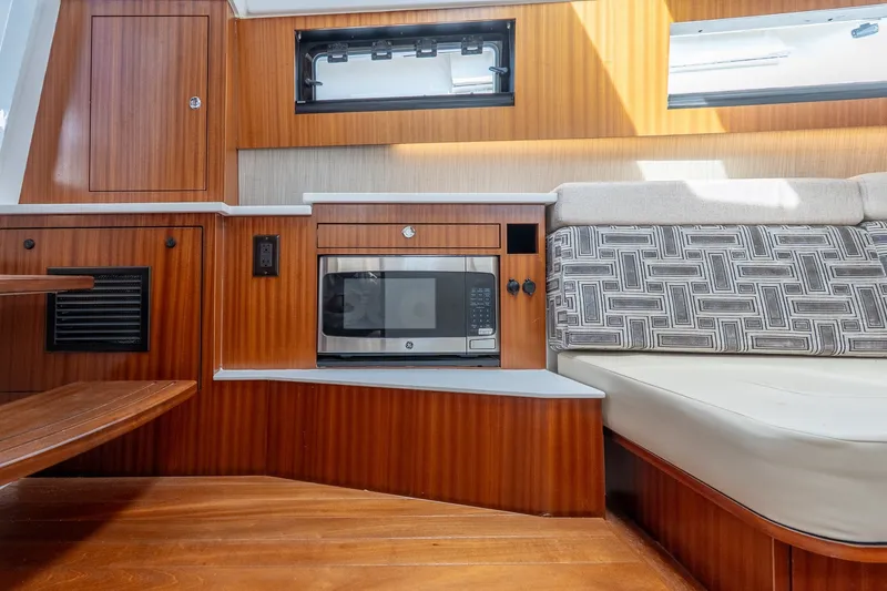 Slide: The Image of 2022 Pursuit S 428 Sport interior with microwave, wood paneling, and patterned seating. - 47