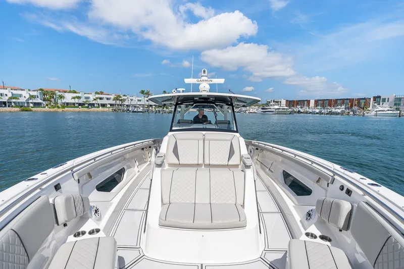 Slide: The Image of 2022 Pursuit S 428 Sport boat on calm water, luxury seating, clear sky. - 45