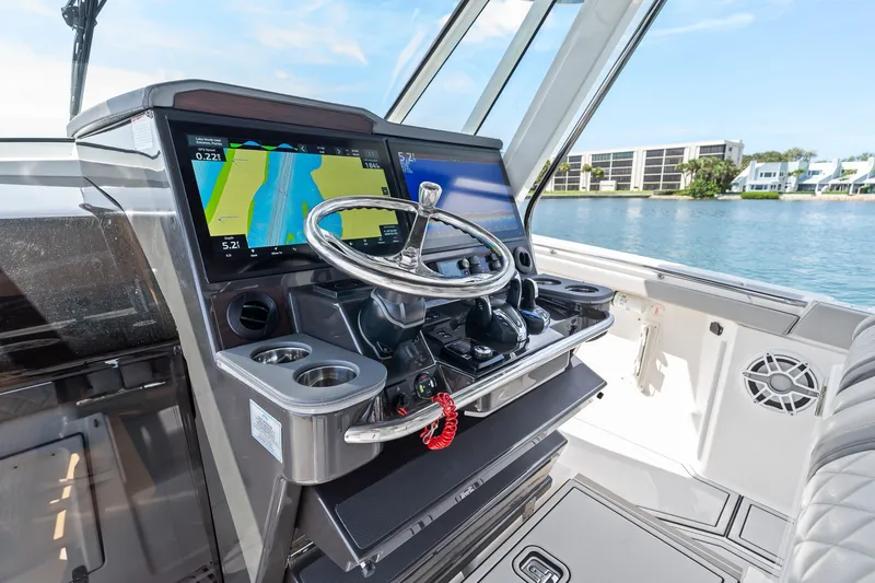 Slide: The Image of 2022 Pursuit S 428 Sport boat helm with navigation screens and steering wheel. - 40