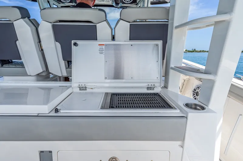 Slide: The Image of Outdoor grill station on 2022 Pursuit S 428 Sport boat, featuring sleek seating and ocean view. - 37