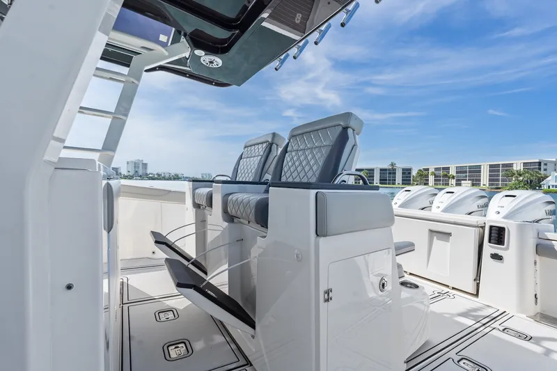 Slide: The Image of 2022 Pursuit S 428 Sport boat interior with luxury seating and multiple outboard engines. - 36