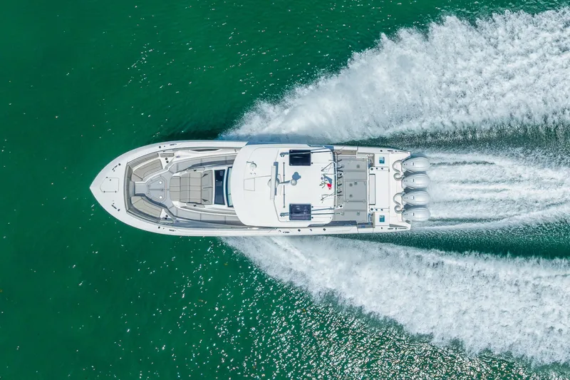 Slide: The Image of Aerial view of 2022 Pursuit S 428 Sport boat speeding on turquoise water. - 17