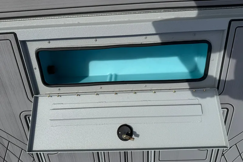 Slide: The Image of Open storage compartment on 2026 Avid 20 Rogue CC boat, featuring a blue interior. - 22