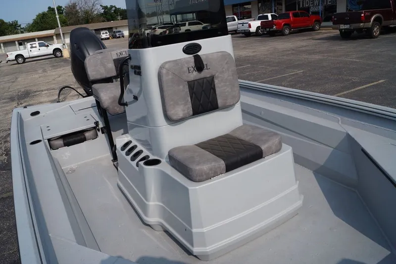 Slide: The Image of 2026 Excel 220 Bay Pro Elite boat interior with gray seating and console in a parking lot. - 7