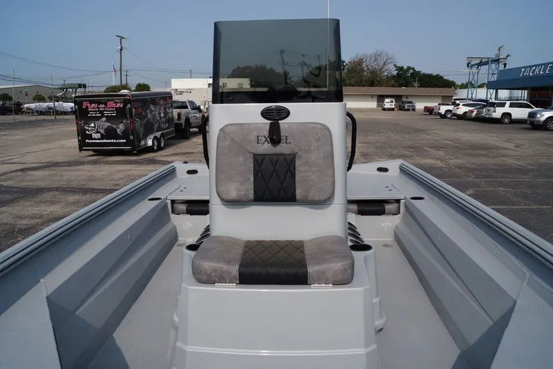 Slide: The Image of 2026 Excel 220 Bay Pro Elite boat interior with seating and console in a parking lot. - 14