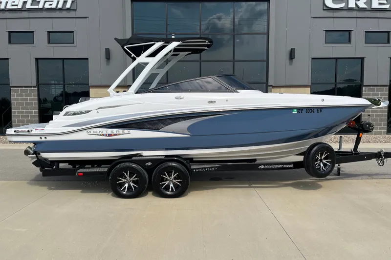 Slide: The Image of 2025 Monterey M6 boat on trailer, parked outside a building, showcasing sleek design and modern features. - 3
