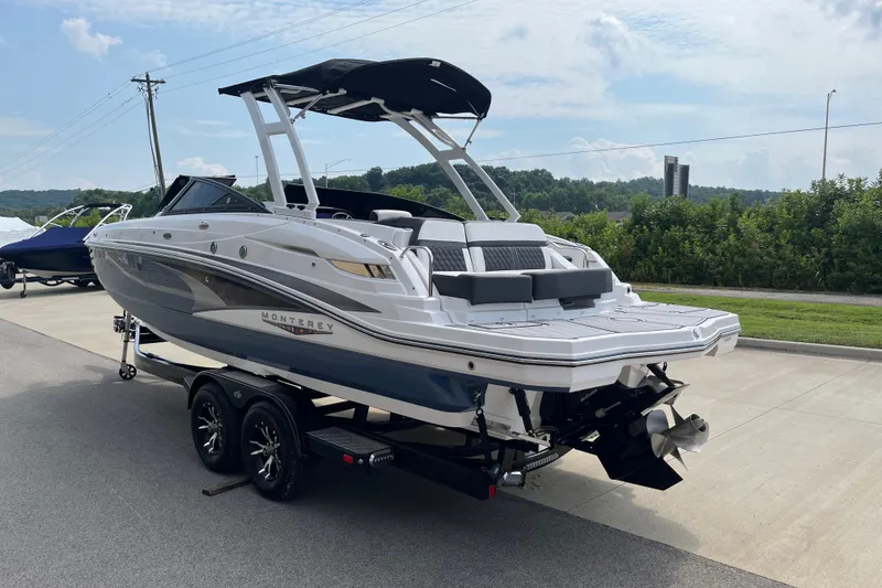 Slide: The Image of 2025 Monterey M6 boat on trailer, parked outdoors under a clear sky. - 7