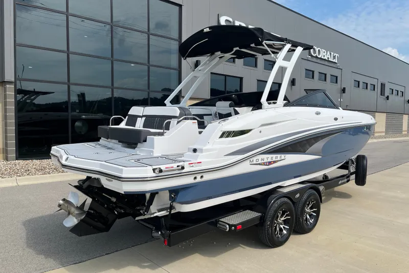 Slide: The Image of 2025 Monterey M6 boat on trailer, parked outside a modern building. - 4