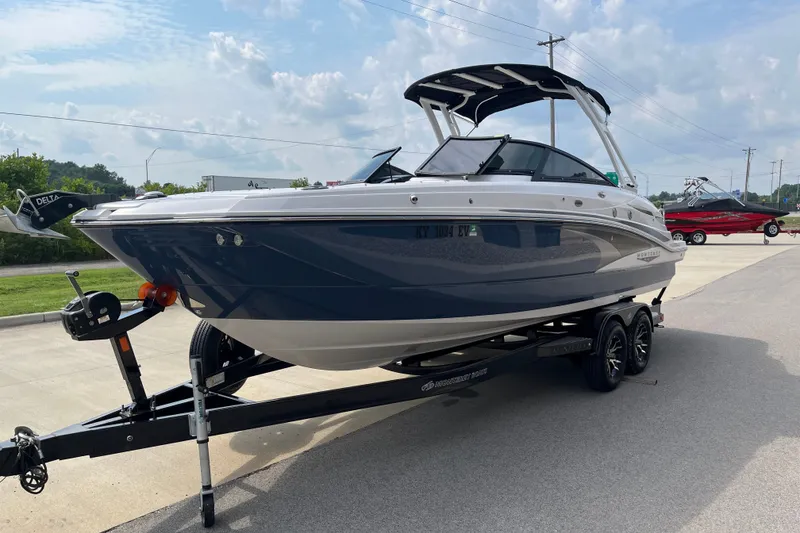 Slide: The Image of 2025 Monterey M6 boat on trailer, sleek design, parked outdoors under cloudy sky. - 5