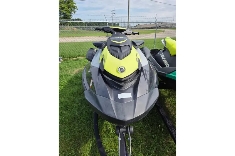The Image of 2020 Sea Doo GTR 230 jet ski in black and yellow, parked on grass. - 1