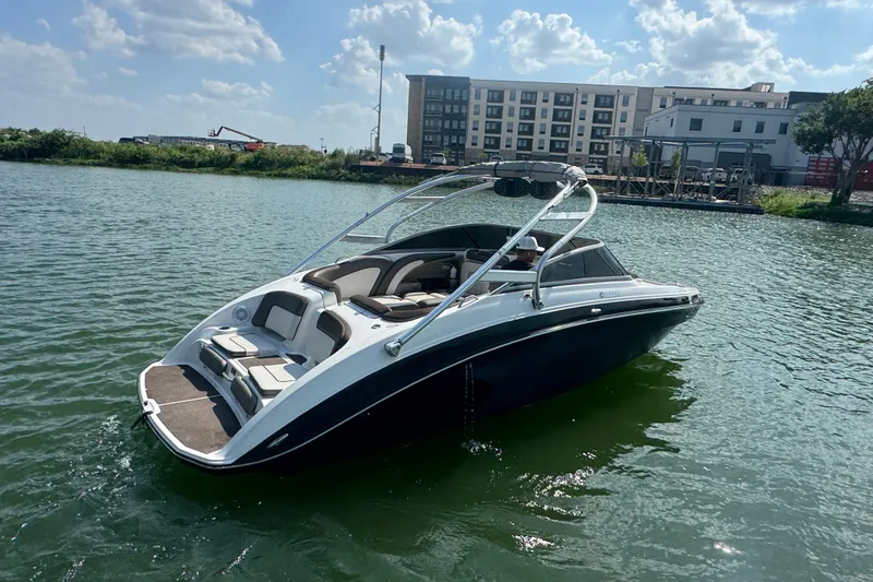 Slide: The Image of 2012 Yamaha Boats 242 Limited S on water, sunny day, urban backdrop. - 4