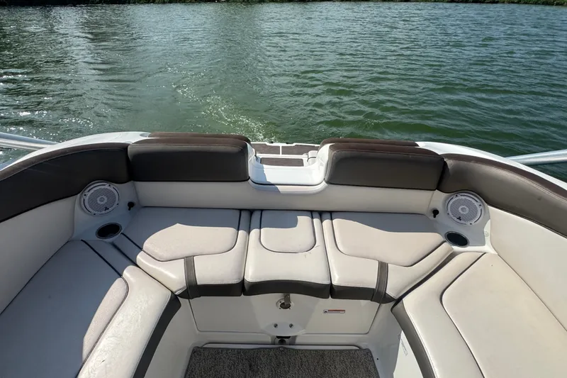 Slide: The Image of 2012 Yamaha Boats 242 Limited S interior seating with speakers, on calm water. - 15