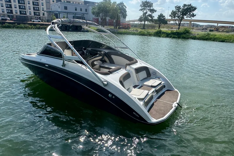 Slide: The Image of 2012 Yamaha Boats 242 Limited S on water, sleek design, sunny day. - 2