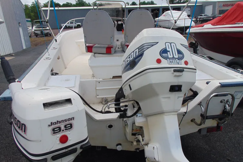 Slide: The Image of 2003 Palm Beach 181 WHITECAP boat with dual Johnson outboard motors in a marina setting. - 4