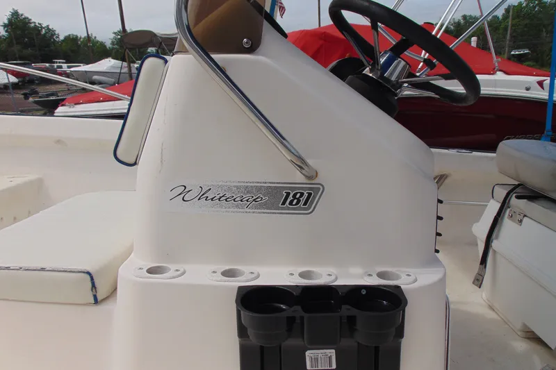 Slide: The Image of 2003 Palm Beach Whitecap 181 boat console with steering wheel and cup holders. - 6
