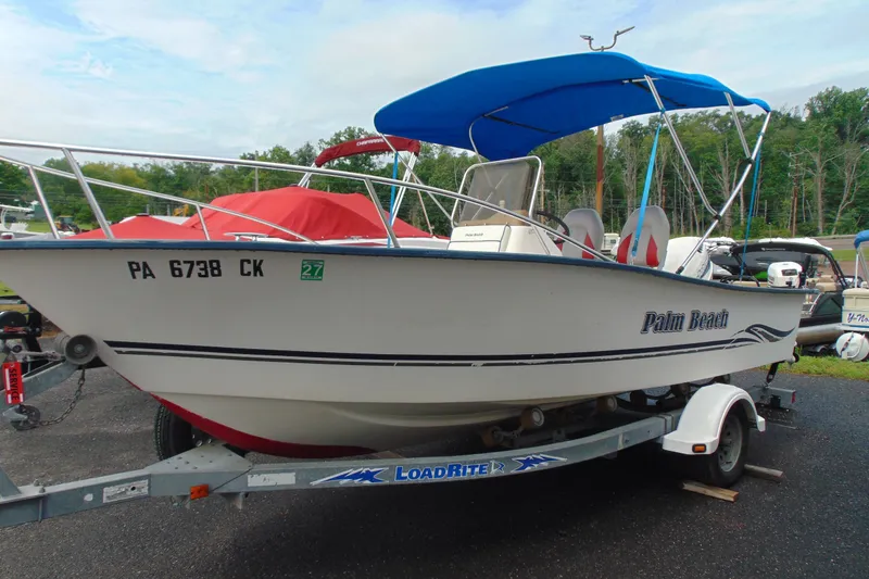 Slide: The Image of 2003 Palm Beach 181 WHITECAP boat on trailer with blue canopy and registration number. - 2