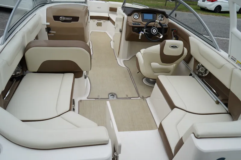 Slide: The Image of 2015 Chaparral 230 Suncoast boat interior with beige and brown seating, steering console. - 12