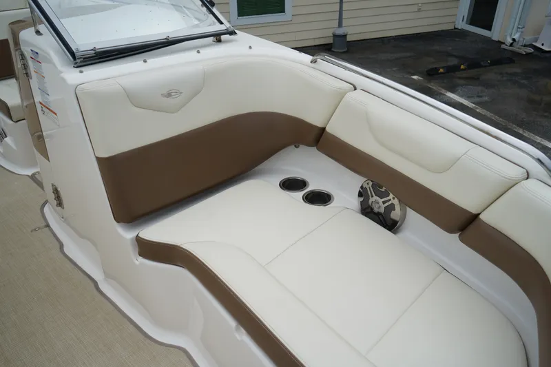 Slide: The Image of 2015 Chaparral 230 Suncoast boat interior with beige and brown seating, cup holders, and speaker. - 5