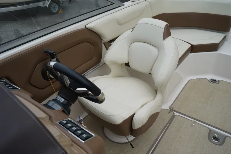 Slide: The Image of Interior of 2015 Chaparral 230 Suncoast boat featuring steering wheel and plush seating. - 6