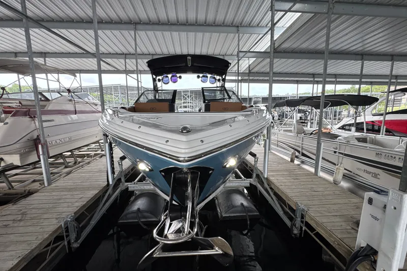 Slide: The Image of 2021 Cobalt R8 Surf boat docked in a covered marina, front view. - 4