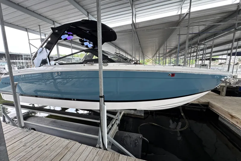 The Image of 2021 Cobalt R8 Surf boat in marina, featuring sleek blue and white design. - 0