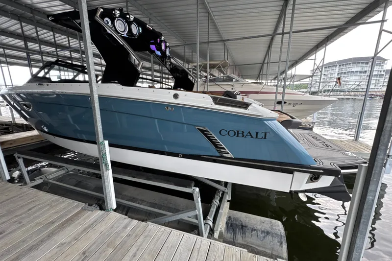 Slide: The Image of 2021 Cobalt R8 Surf boat docked in a marina under a metal roof. - 1