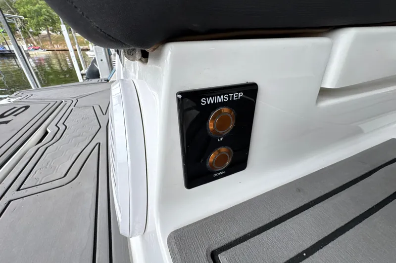 Slide: The Image of 2021 Cobalt R8 Surf boat swim step controls on deck, featuring up and down buttons. - 39