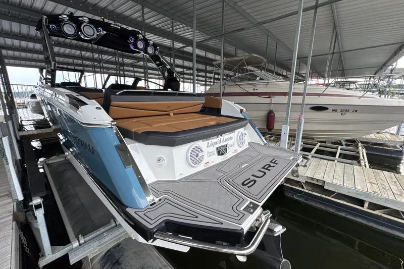 Slide: The Image of 2021 Cobalt R8 Surf boat docked, featuring sleek design and advanced audio system. - 6