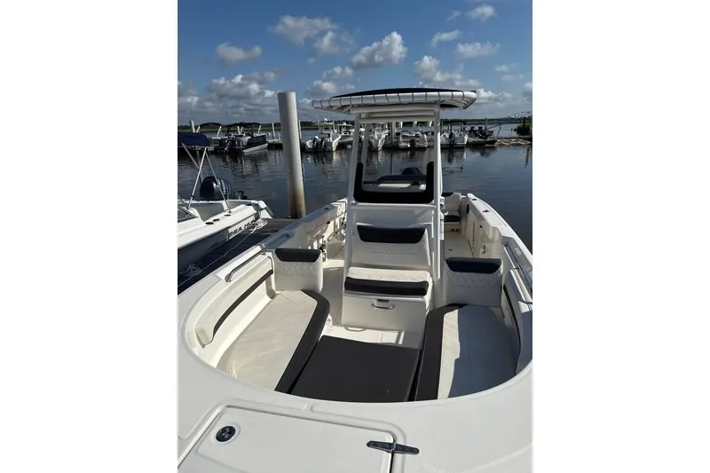 Slide: The Image of 2023 Trophy CC24 boat docked at marina under blue sky. - 2