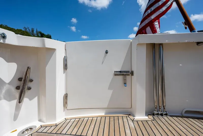 Slide: The Image of Stern of a boat with wooden deck and American flag, surrounded by blue sky. - 22