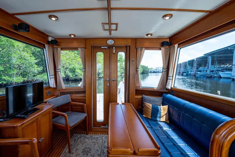 Slide: The Image of Interior of the 2007 Grand Banks 43 Eastbay SX with wooden furnishings and large windows. - 2