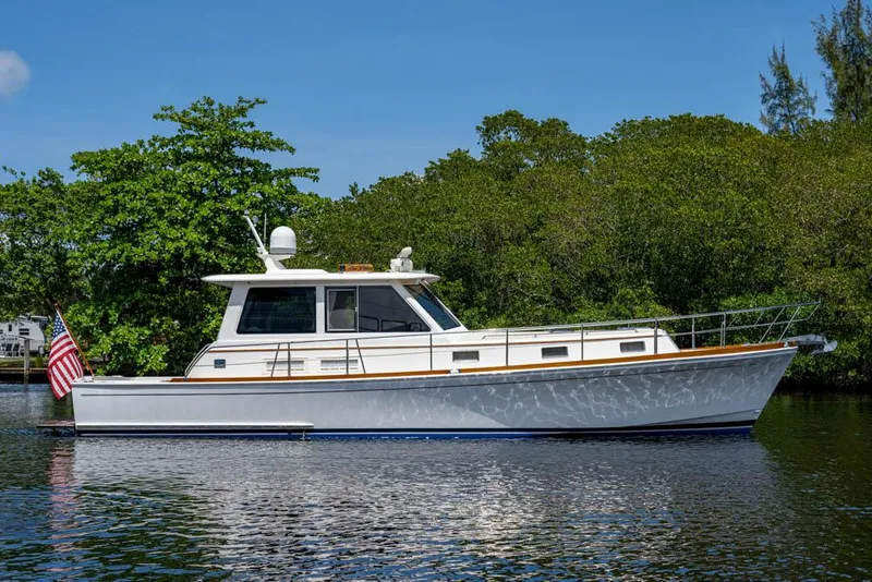 The Image of A 2007 Grand Banks 43 Eastbay SX on calm water, surrounded by lush greenery. - 0