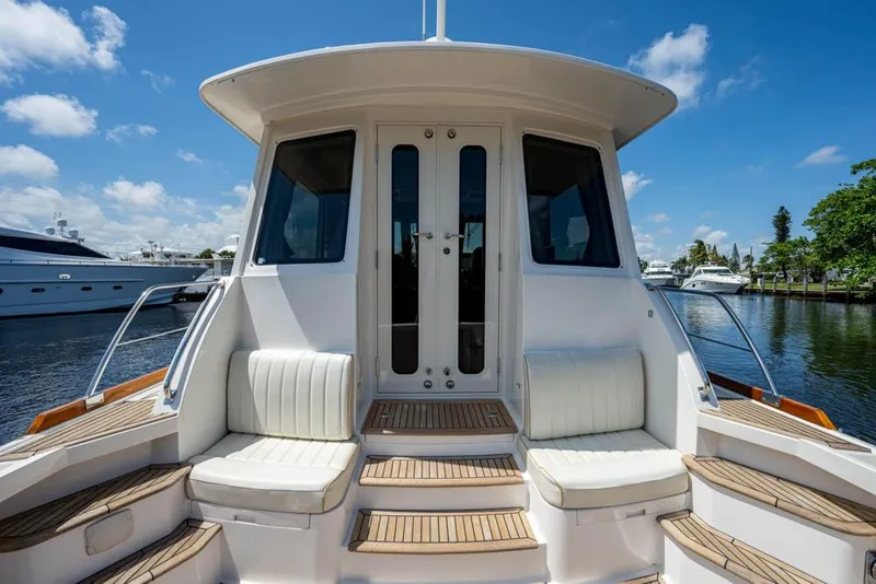 Slide: The Image of The 2007 Grand Banks 43 Eastbay SX features an elegant stern view with cushioned seating and wood accents. - 26