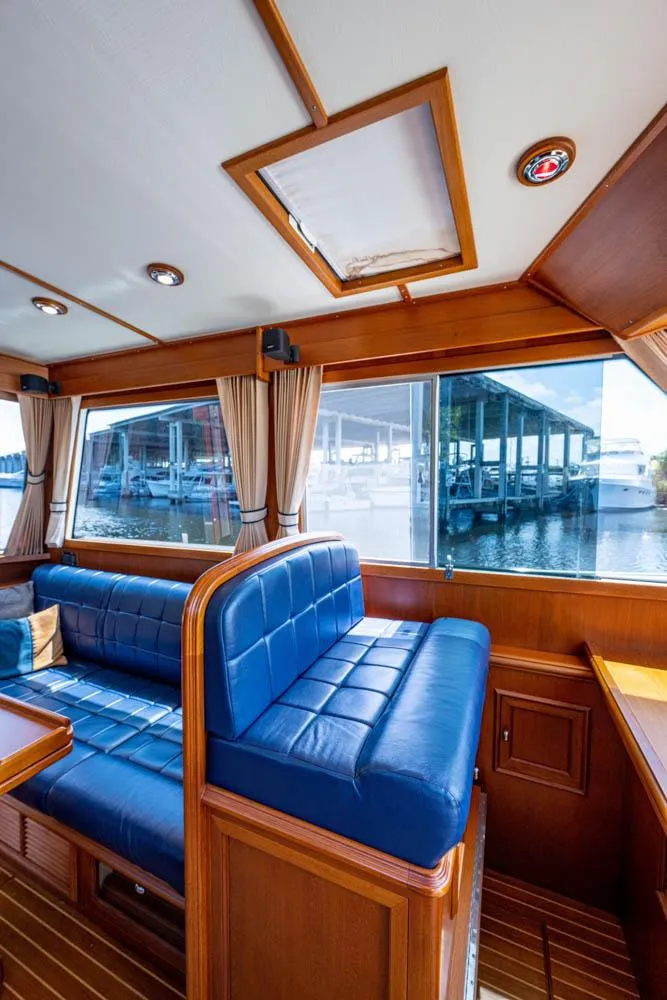 Slide: The Image of Interior of a 2007 Grand Banks 43 Eastbay SX with blue leather seating and wood finish. - 32