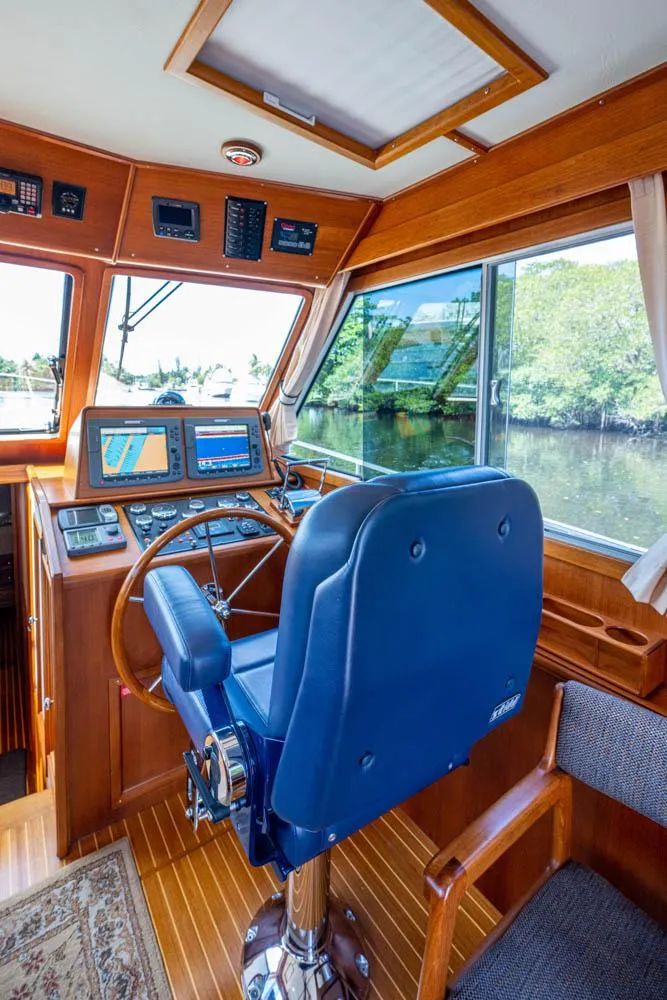 Slide: The Image of Interior view of a 2007 Grand Banks 43 Eastbay SX helm with wood finish and blue captain's chair. - 3