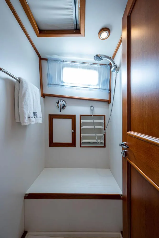 Slide: The Image of Bathroom with wooden door, shower, towel rack, and window. Sleek, compact design. - 46