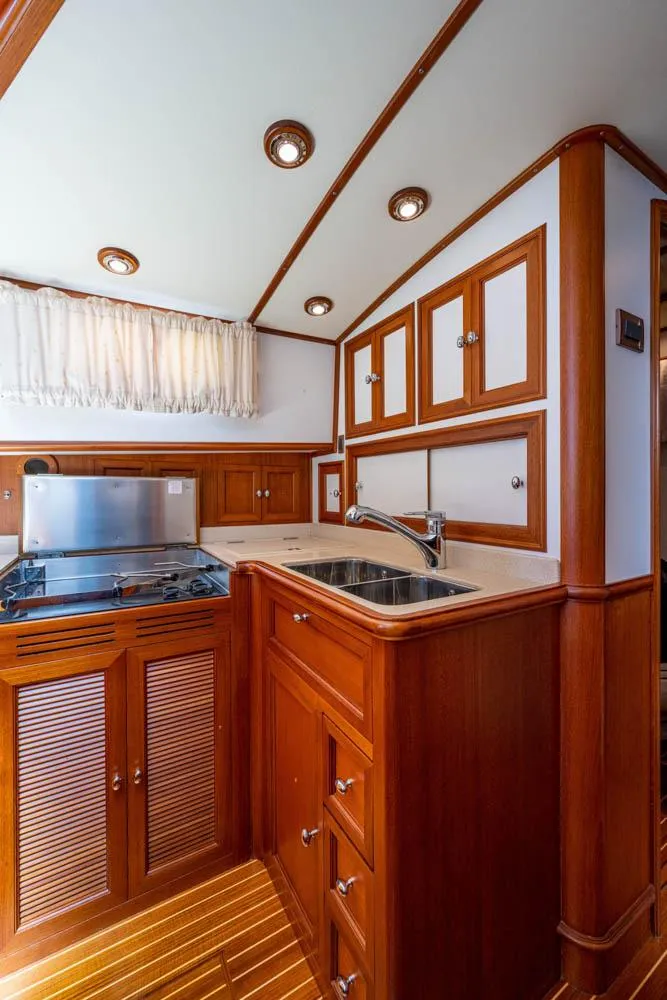 Slide: The Image of The 2007 Grand Banks 43 Eastbay SX galley features elegant wood cabinetry and modern fixtures. - 4